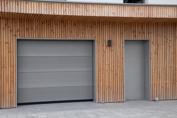 facade of modern wooden house with terrace and closed pvc rolling shutters of new suburban home